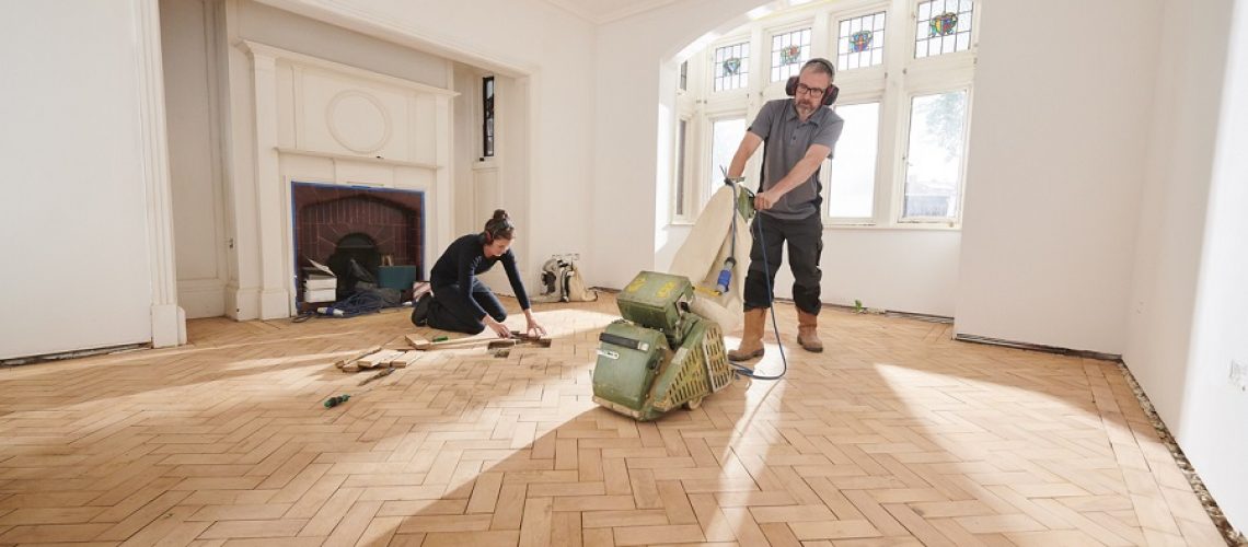 two workers repair and restore a parquet period floor